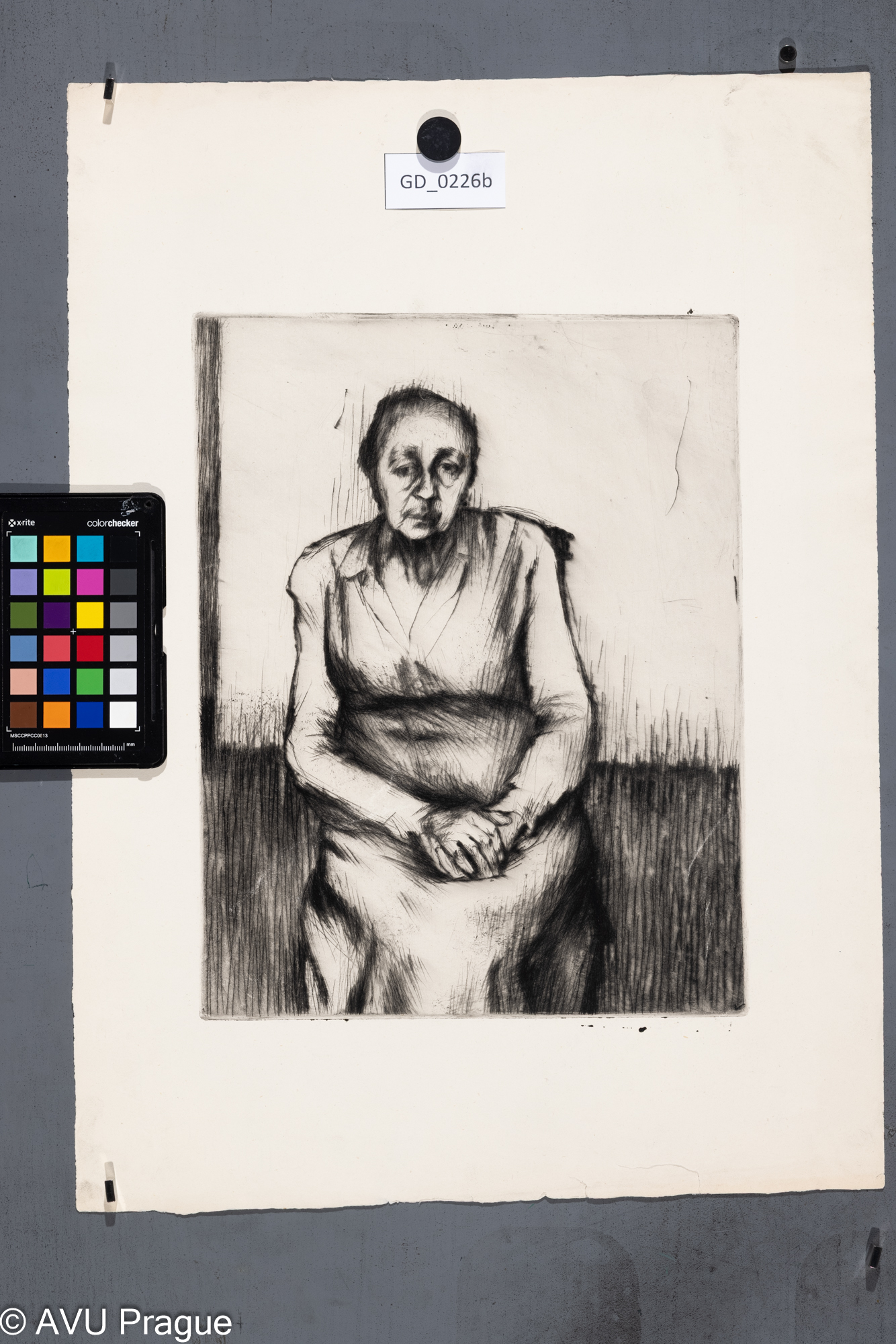 Sedicí stará žena s rukama v klíně