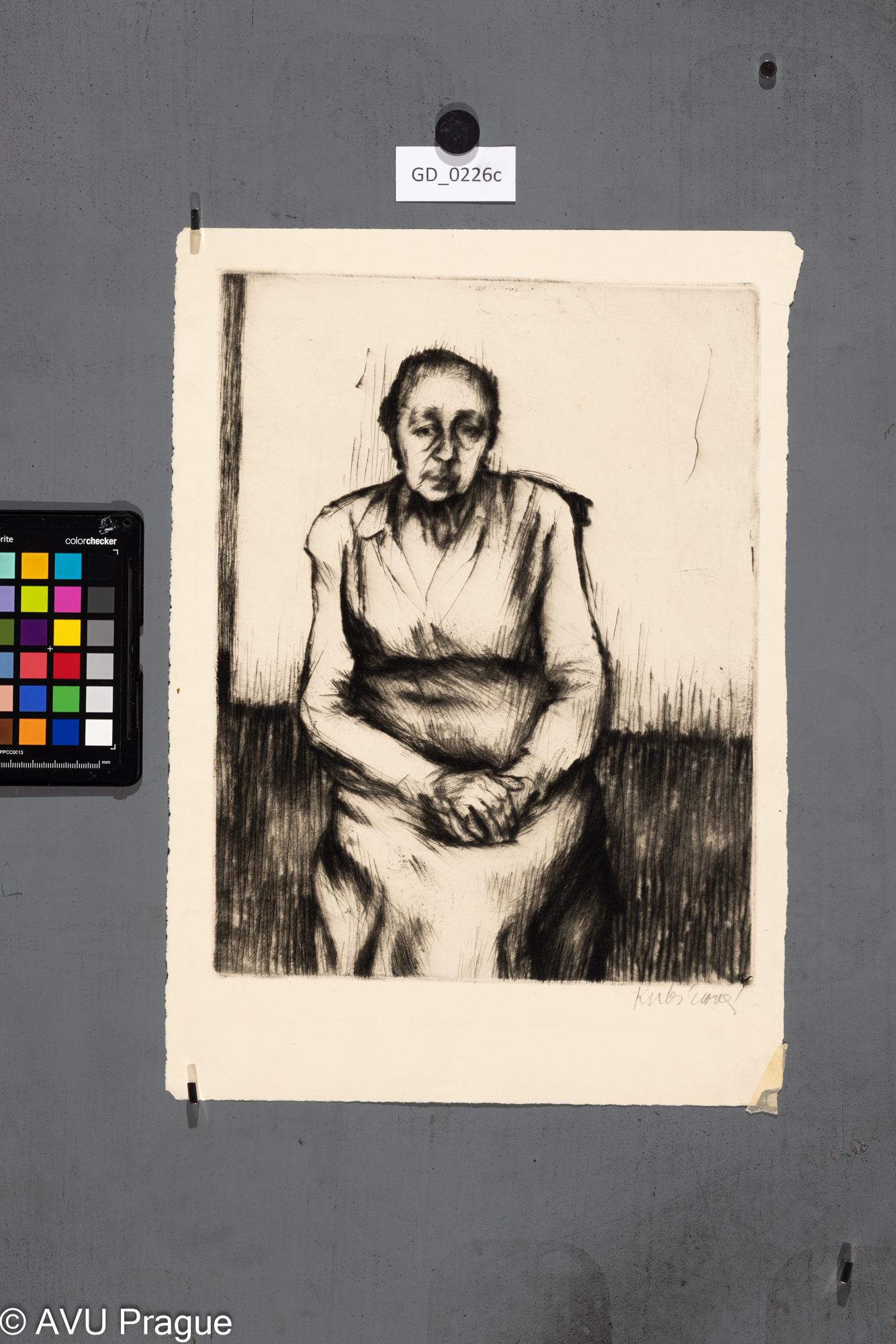 Sedicí stará žena s rukama v klíně